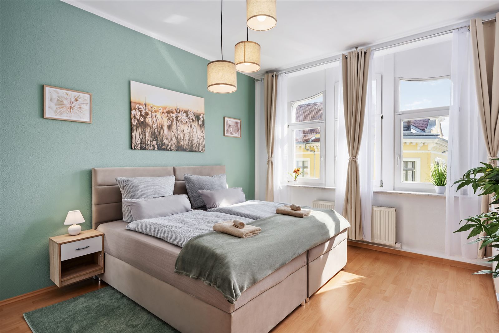 Helles Schlafzimmer mit Doppelbett und Blick auf Meißens Altbaufassaden – ruhig und erholsam