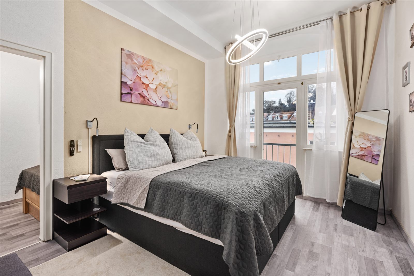 Elegantes Schlafzimmer mit bodentiefem Fenster und Stadtblick – viel Tageslicht und ein Hauch von Urlaubsluxus