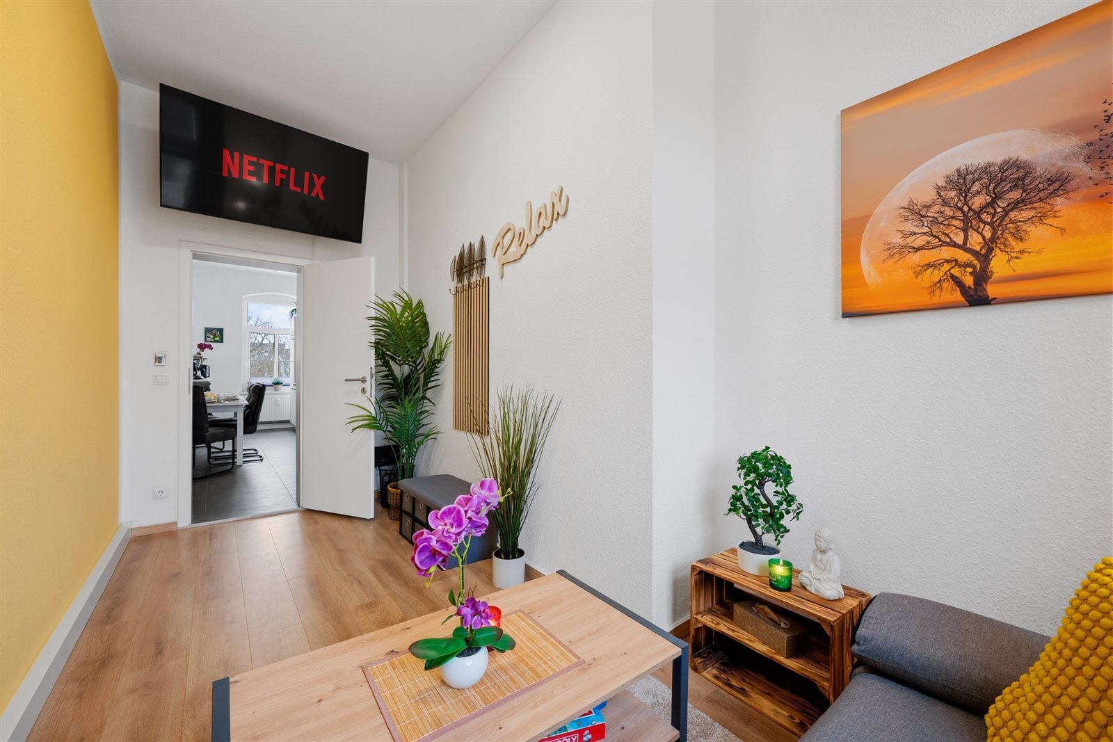Wohnbereich mit Smart-TV und Blick zum Arbeitszimmer – fließender Übergang zwischen Entspannen und Arbeiten